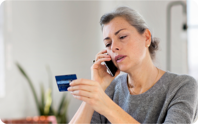 A woman relays her credit card number over the phone to a merchant, who can accept her payment