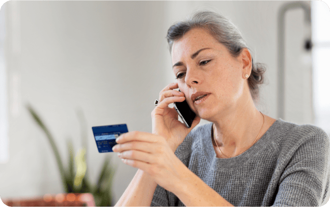 A woman relays her credit card number over the phone to a merchant, who can accept her payment