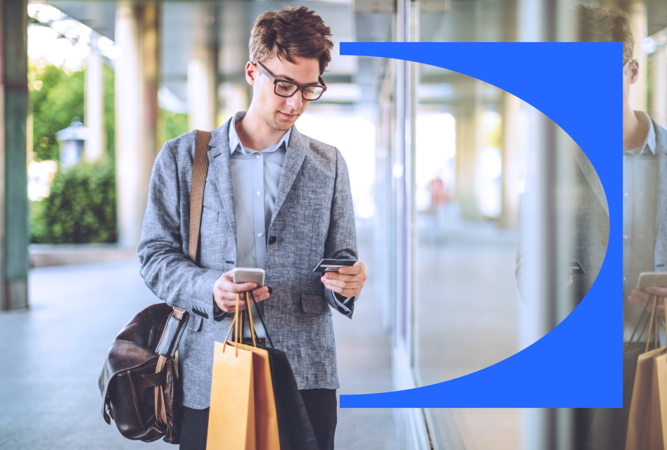 A customer looks at his mobile device while holding a recent purchase