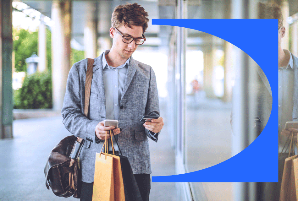 A customer looks at his mobile device while holding a recent purchase