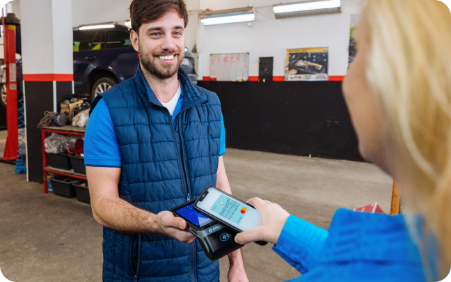A man and a woman tap their mobile phones together to conduct a payment transaction