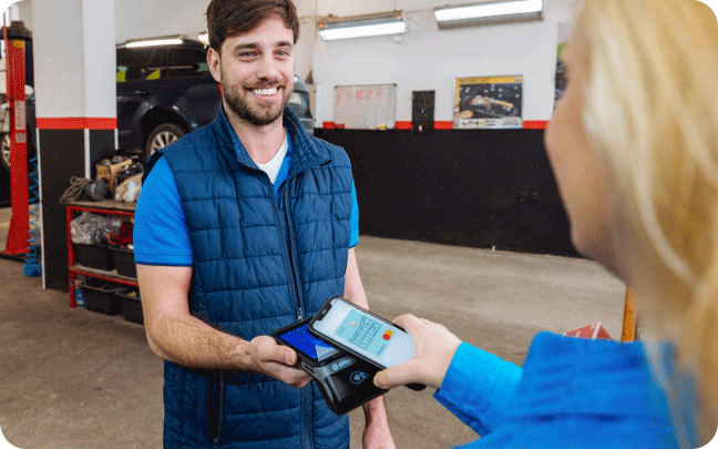A man and a woman tap their mobile phones together to conduct a payment transaction