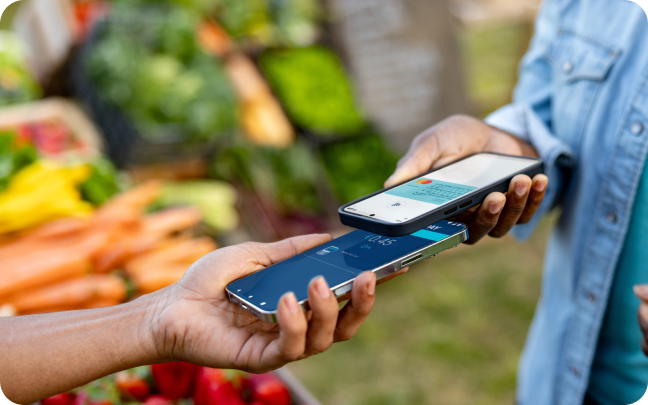 Two customers tap their mobiles phones together to conduct a payment