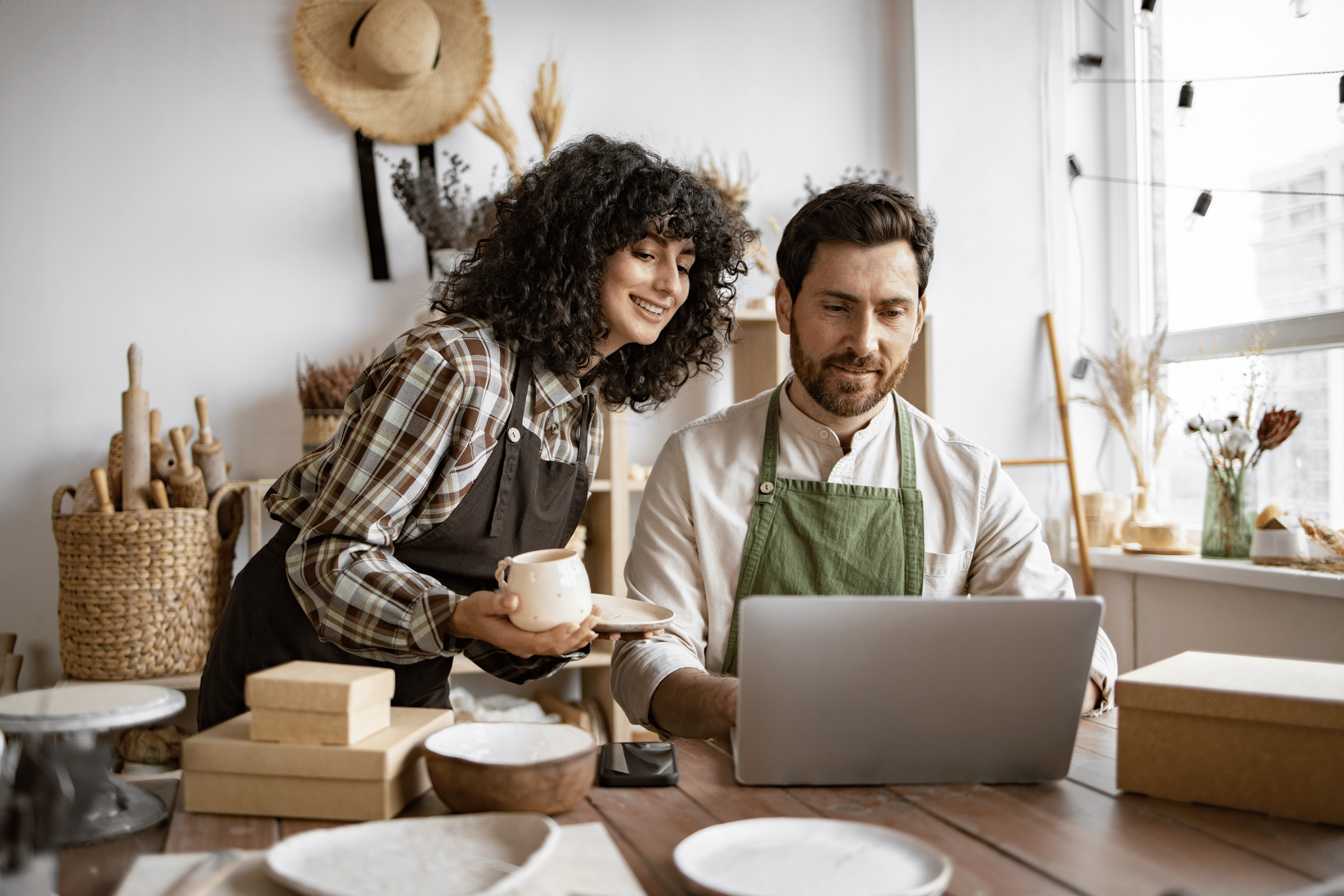 A woman leans over the shoulder of her male teammate to analyze business insights from a computer